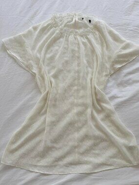 White polka dot sheer blouse with ruffle neckline and short sleeves